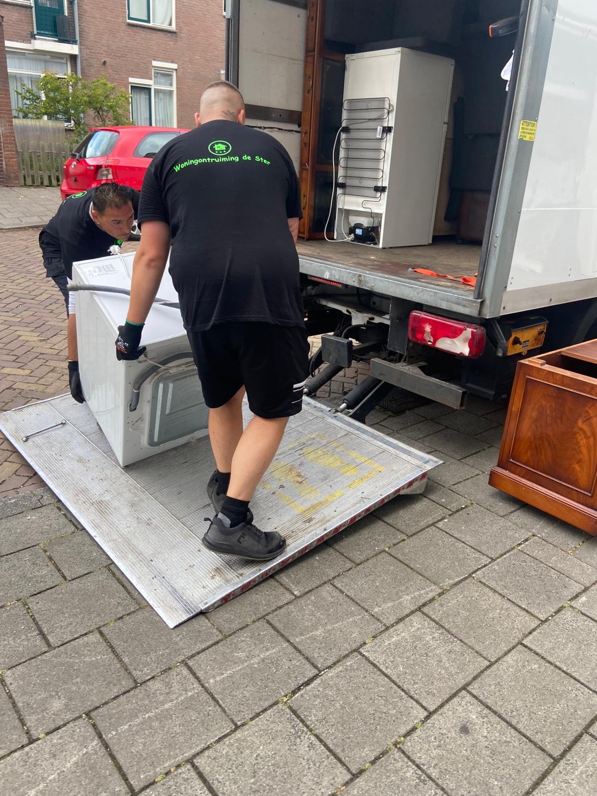 Medewerker laadt witgoed in de verhuiswagen