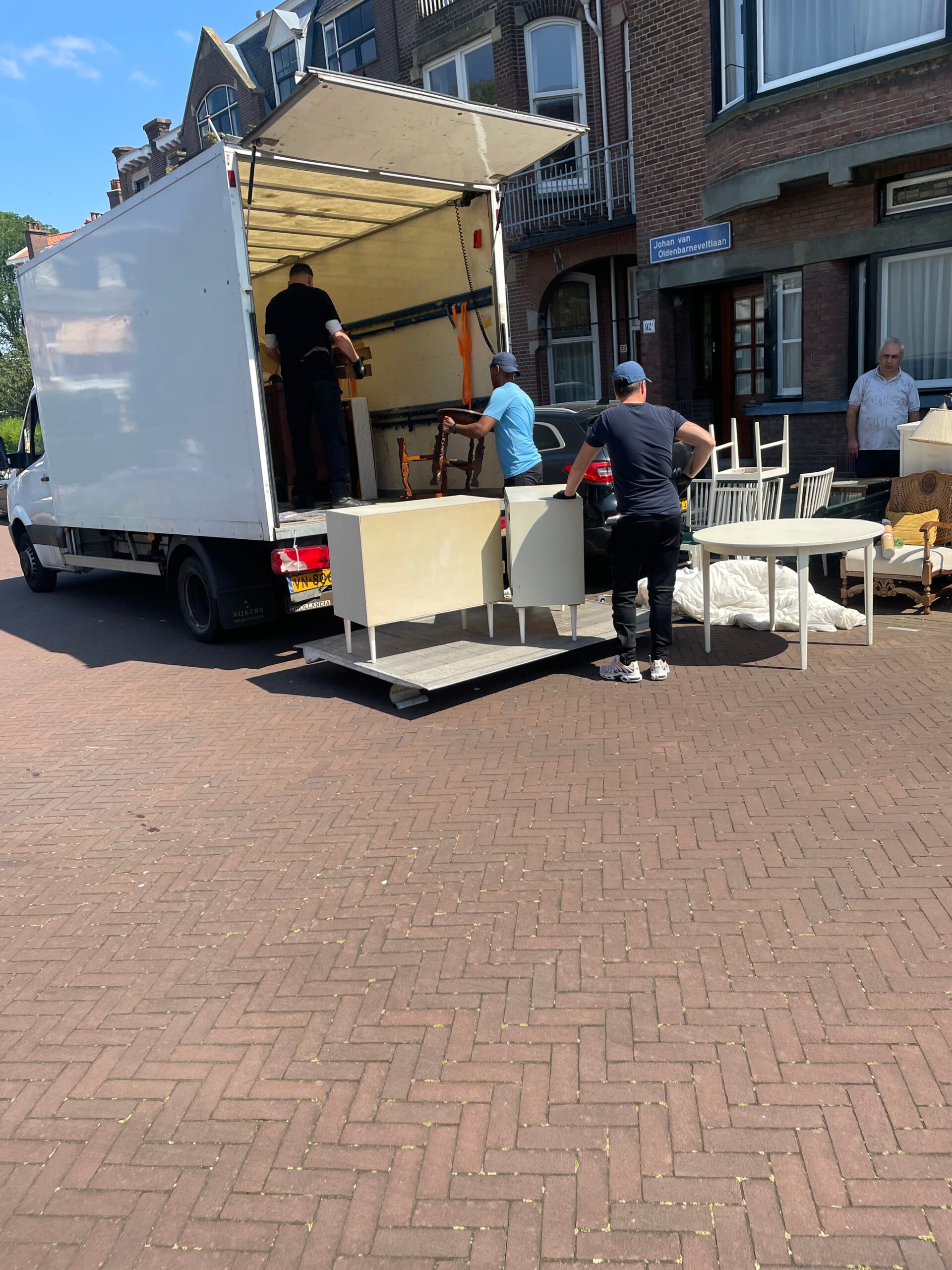 Volgeladen verhuiswagen bij een woning