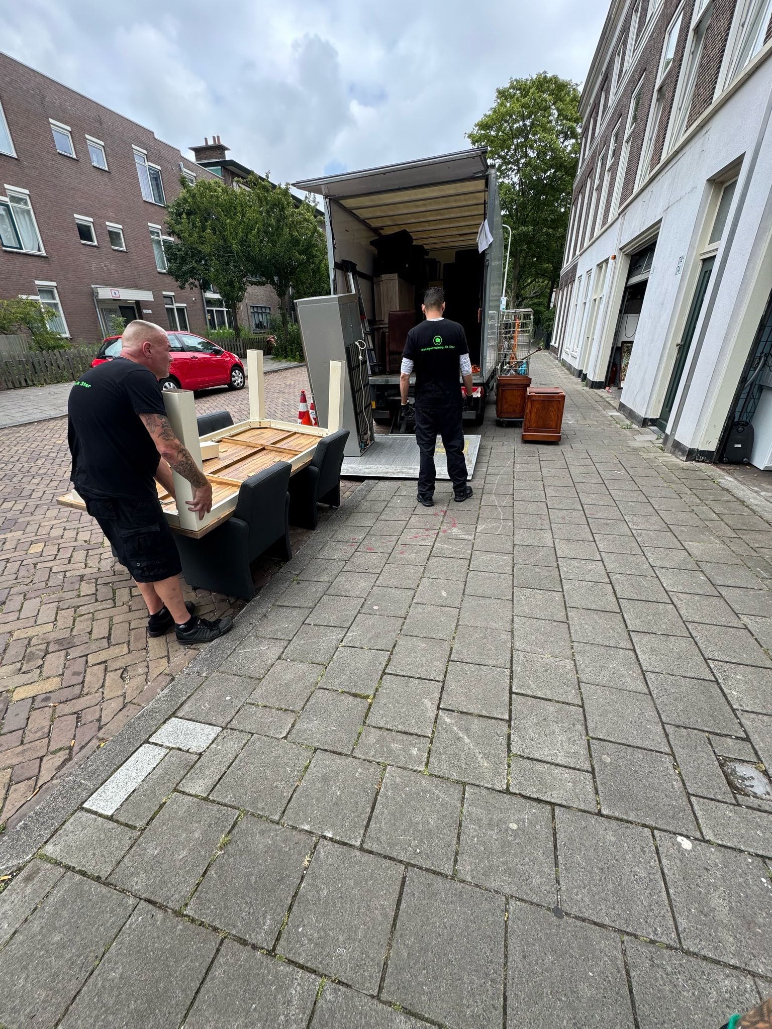 Medewerkers dragen een bank naar de verhuiswagen